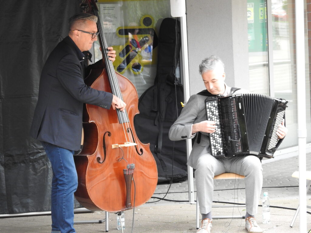 Dwóch mężczyzn grających na instrumentach.