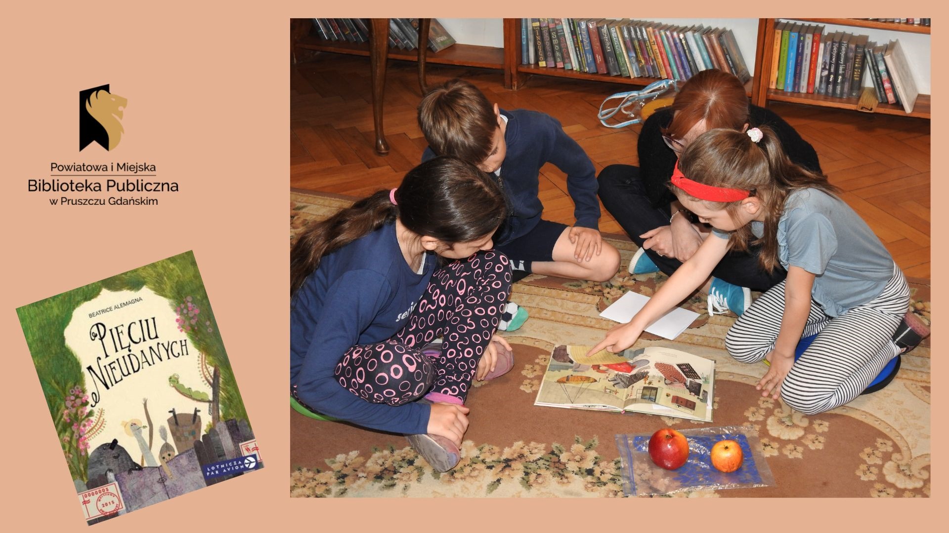 Troje dzieci oraz jedna osoba dorosła siedzą obok siebie na dywanie i pochylają się nad otwartą książką. Jedno dziecko wskazuje palcem na jakiś element w książce. Obok książki leży woreczek foliowy, na którym znajdują się dwa jabłka.