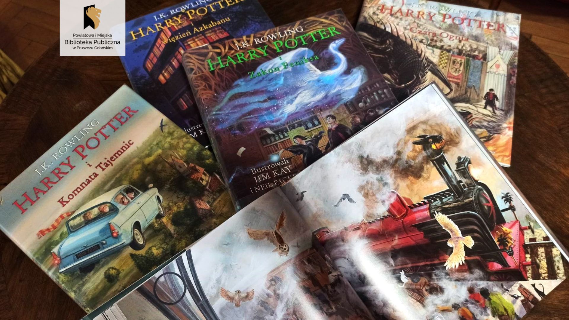 Na stole leży 5 książek – różne części z serii Harry Potter. Jedna z książek jest otwarta na ilustracji pociągu.