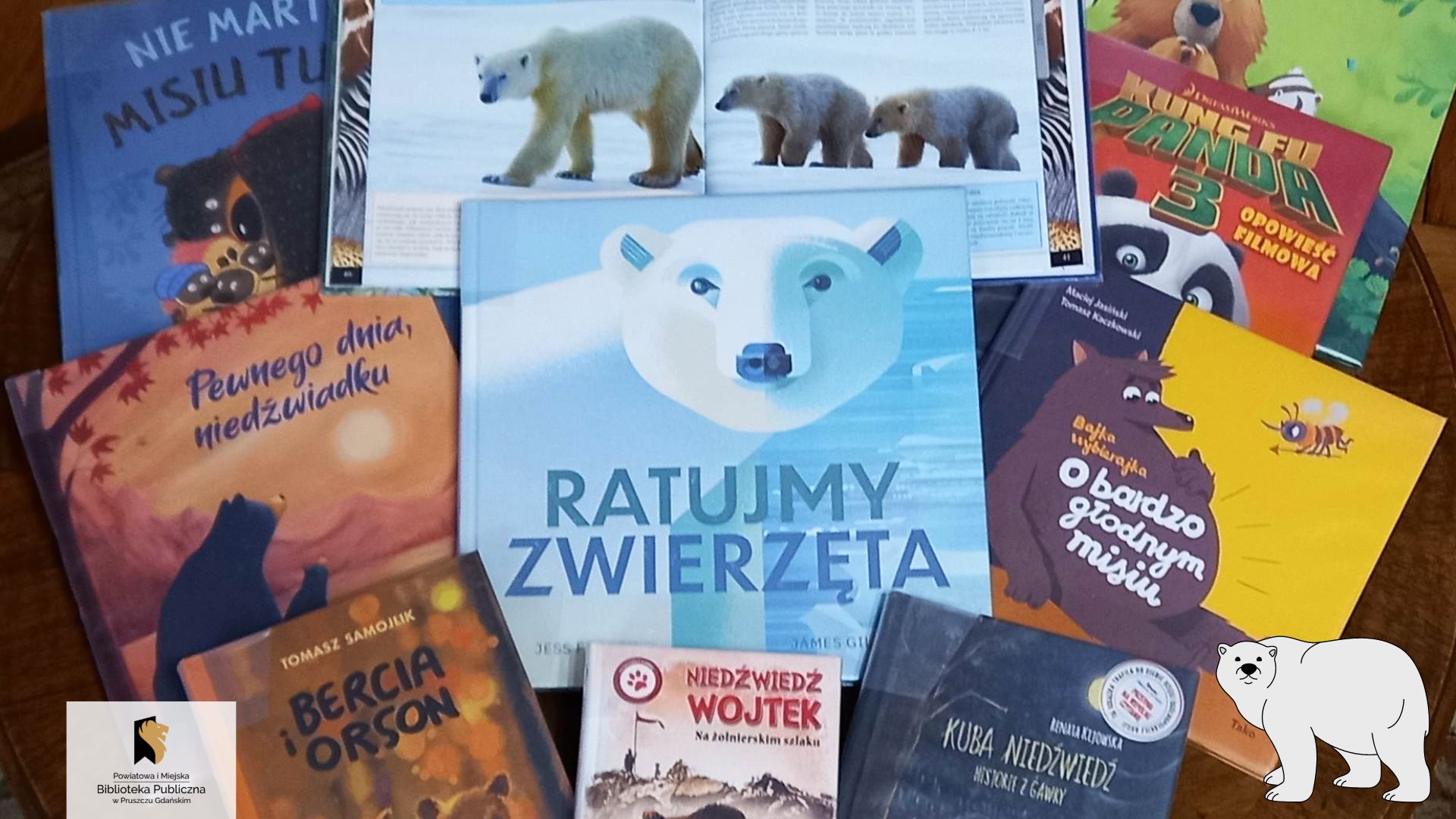 Na brązowym tle ułożone są książki. Po środku znajduje się książka pt. „Ratujmy zwierzęta” z niedźwiedziem polarnym na okładce. Nad nią leży otwarta książka, na której znajdują się trzy niedźwiedzie.