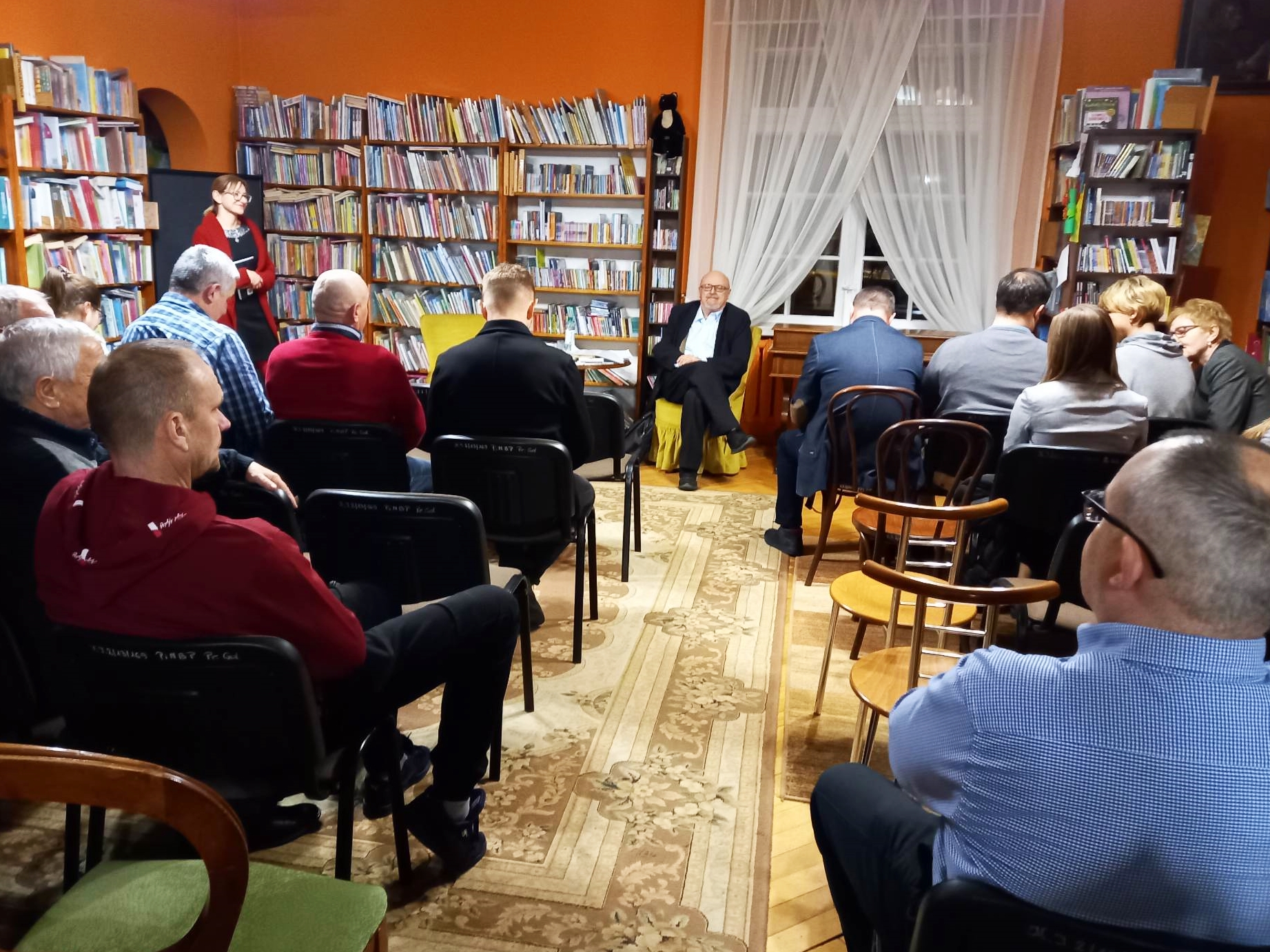 Wiesław Wika oraz czytelnicy obecni na spotkaniu autorskim w bibliotece.