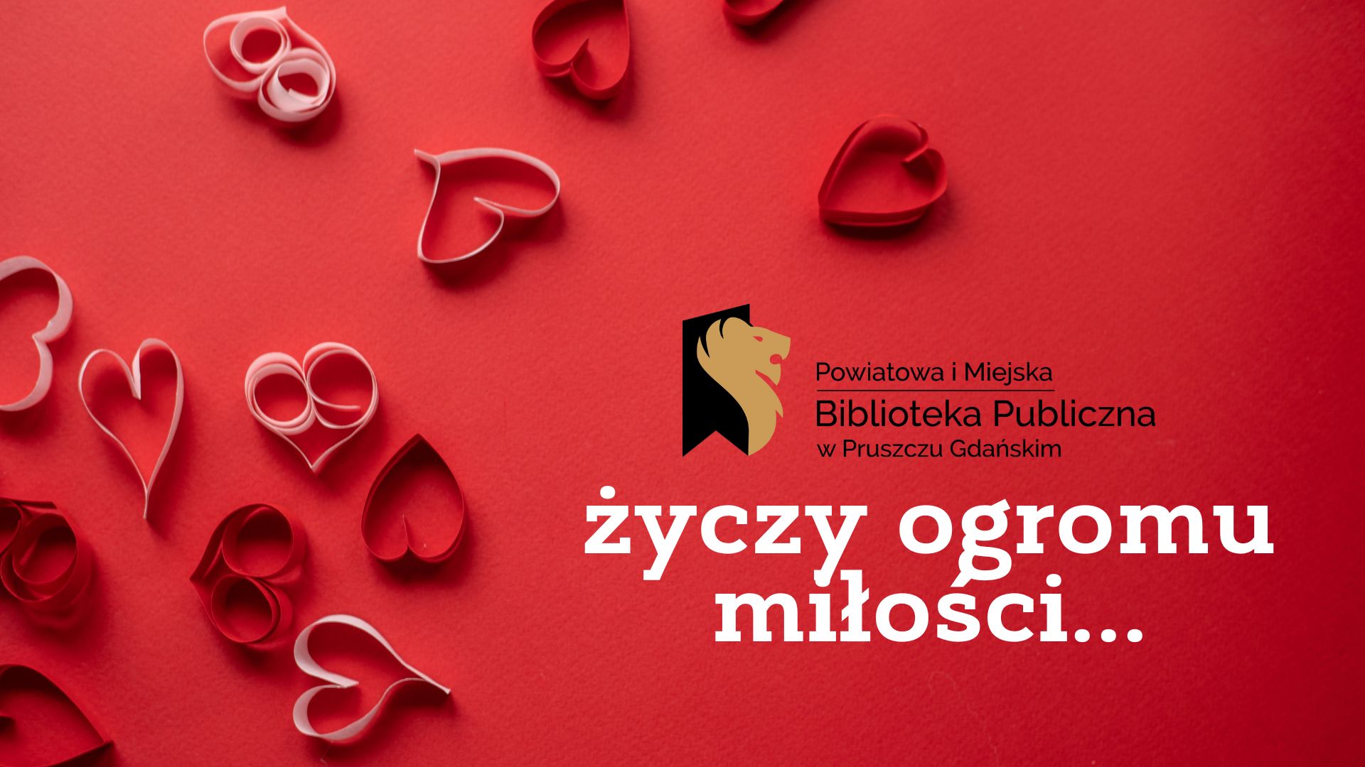 Na czerwonym tle logo biblioteki oraz napis: Powiatowa i Miejska Biblioteka Publiczna w Pruszczu Gdańskim życzy ogromu miłości… Obok białe i czerwone serca z papieru.