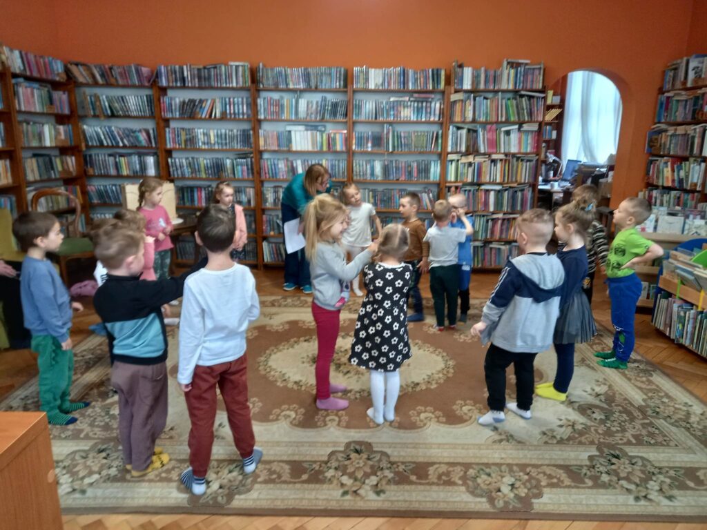 Dzieci bawią się z bibliotekarką w motyle.
