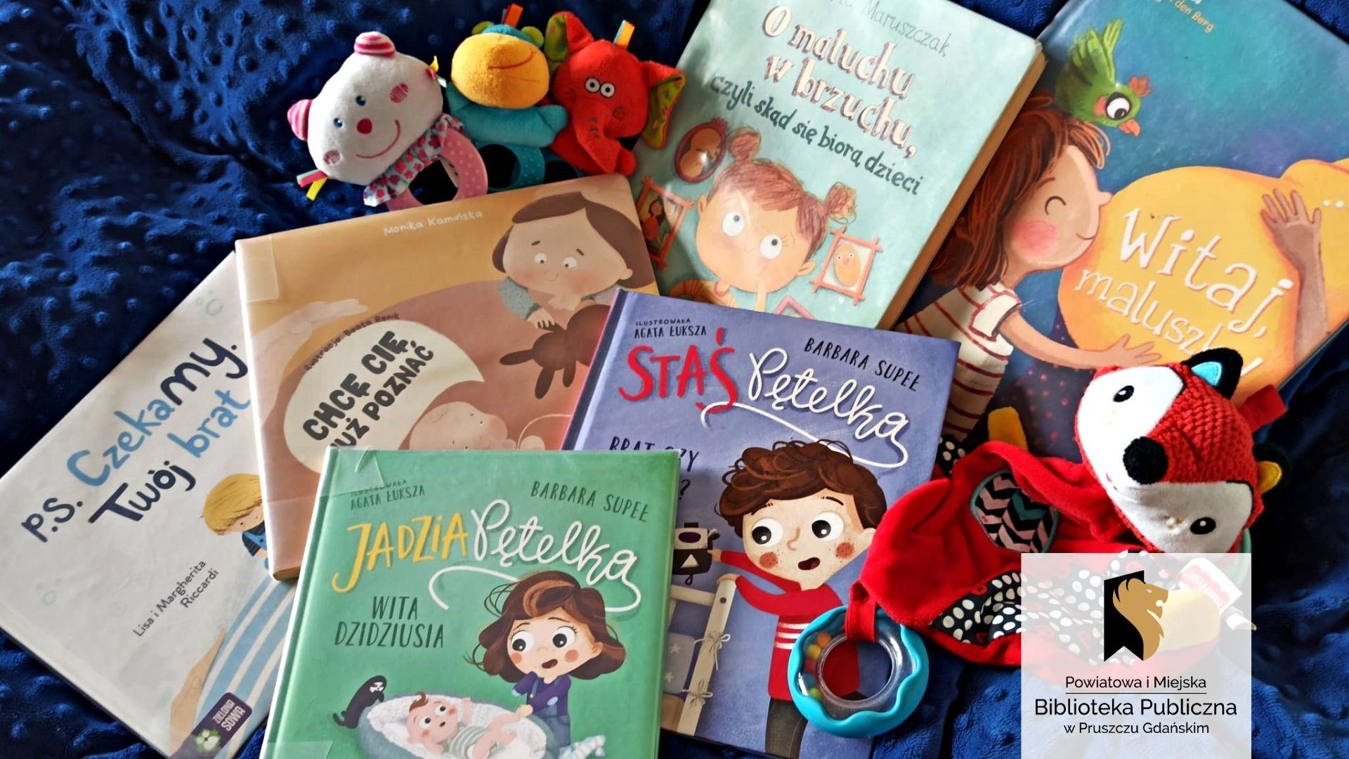Na niebieskim kocu leży sześć opisanych w tekście książek. Na okładkach znajdują się ilustracje kilkuletnich dzieci, czasami w towarzystwie młodszego rodzeństwa. Pomiędzy książkami ułożonych jest kilka zabawek dla niemowląt.