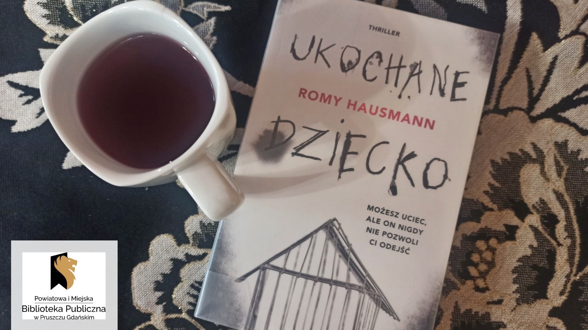 Książka — thriller Romy Haussman pt. Ukochane dziecko. Obok filiżanka z napojem.
