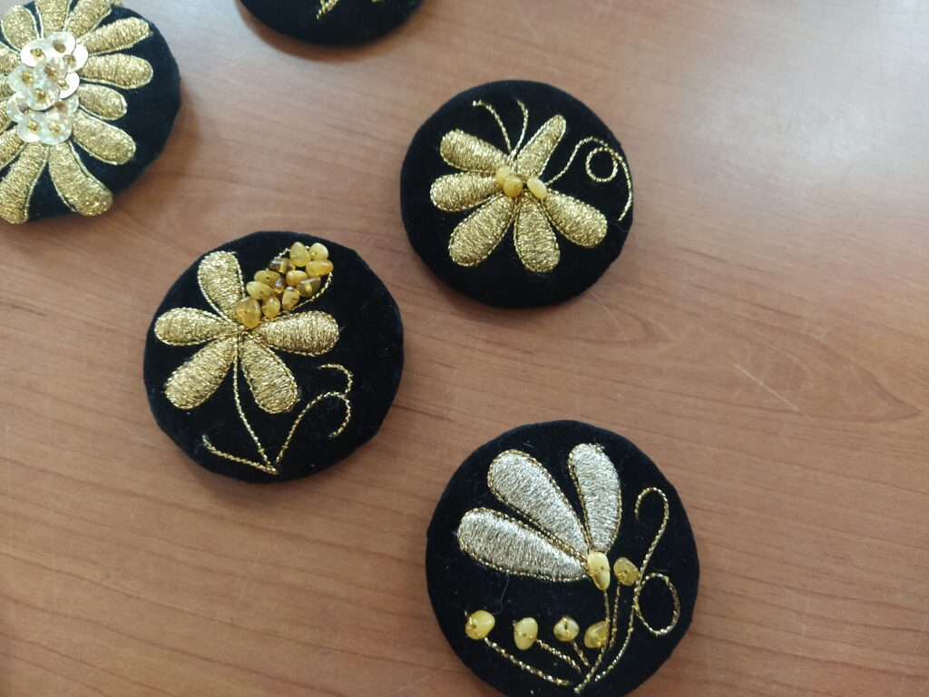 4 broszki haftowane złotnicą kaszubską oraz ozdobione bursztynem.